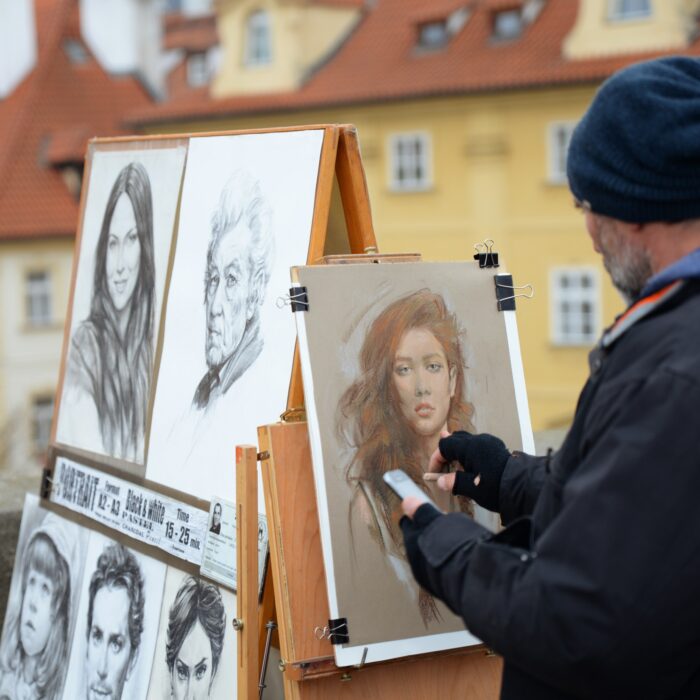 An artist painting a portrait outdoors