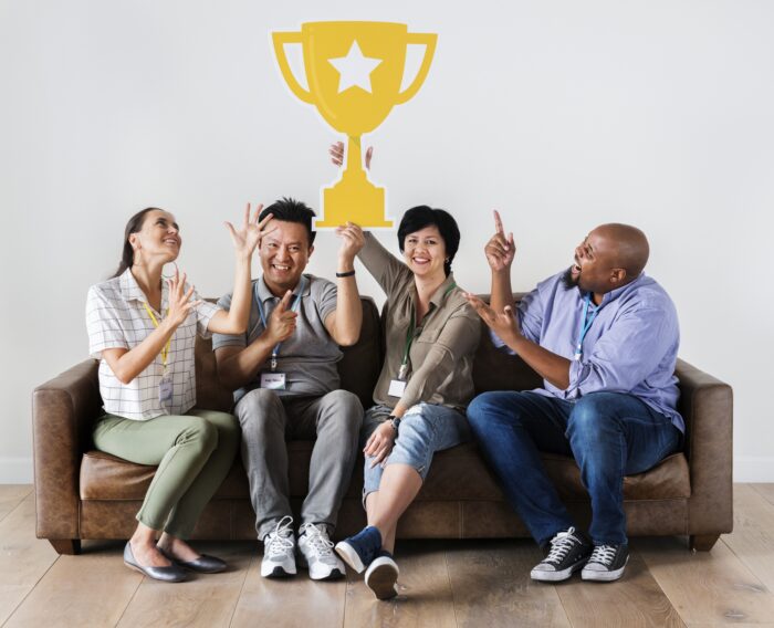 Employee Appreciation Gift Ideas: A group of employees holding a trophy