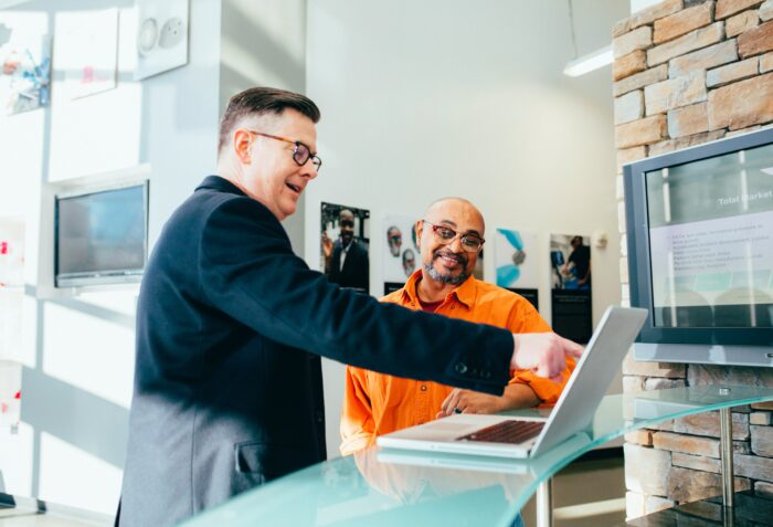 An man helping a customer with a computer 