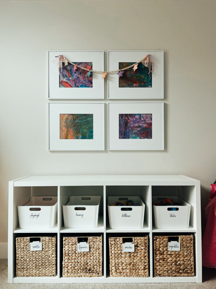 5 Clever Ways To Save Money On Home Decor: A cute storage setup with children's art framed. 