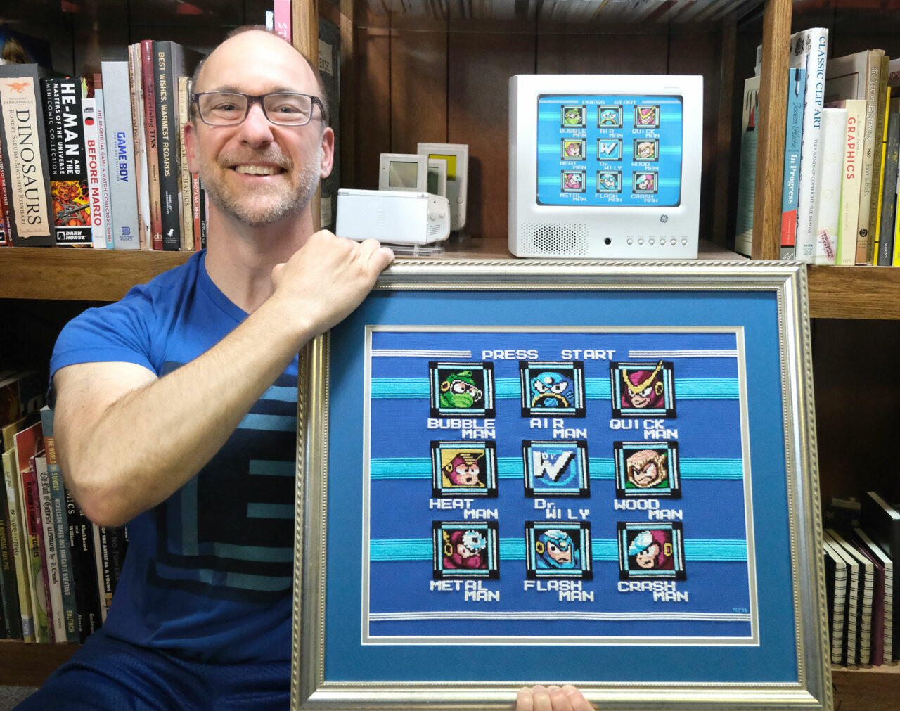 man holding gamer art in silver picture frame