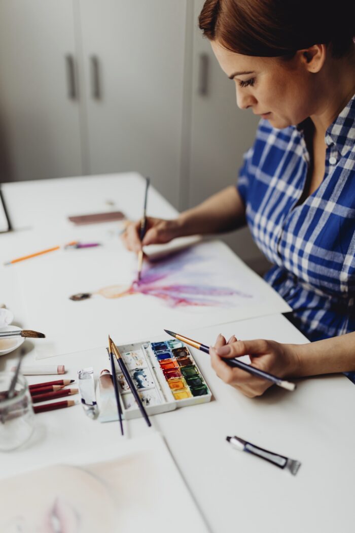 selling art on Etsy: A lady practicing watercolor art for her Etsy store