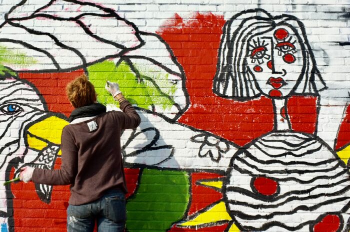 Emerging Art Trends: An artist painting a brick wall 