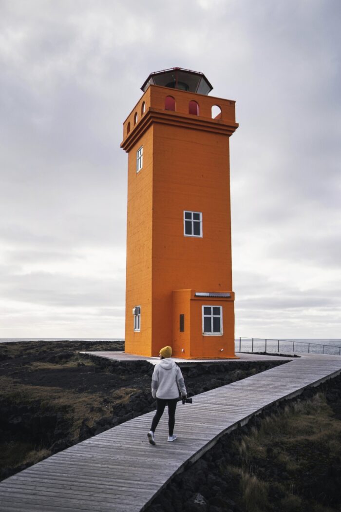 Architecture Photography & Real Estate Pictures: An orange lighthouse on a cloudy day