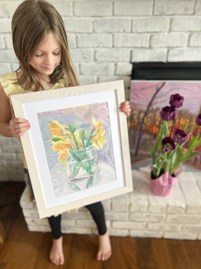 A child holding a framed art print