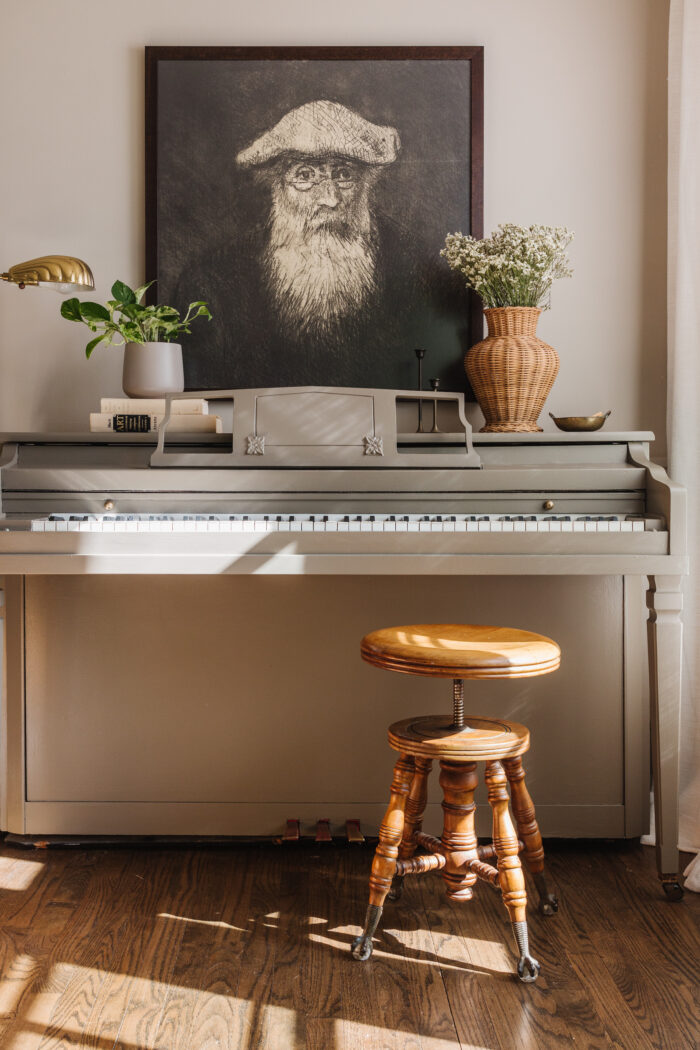 A large framed painting over a piano