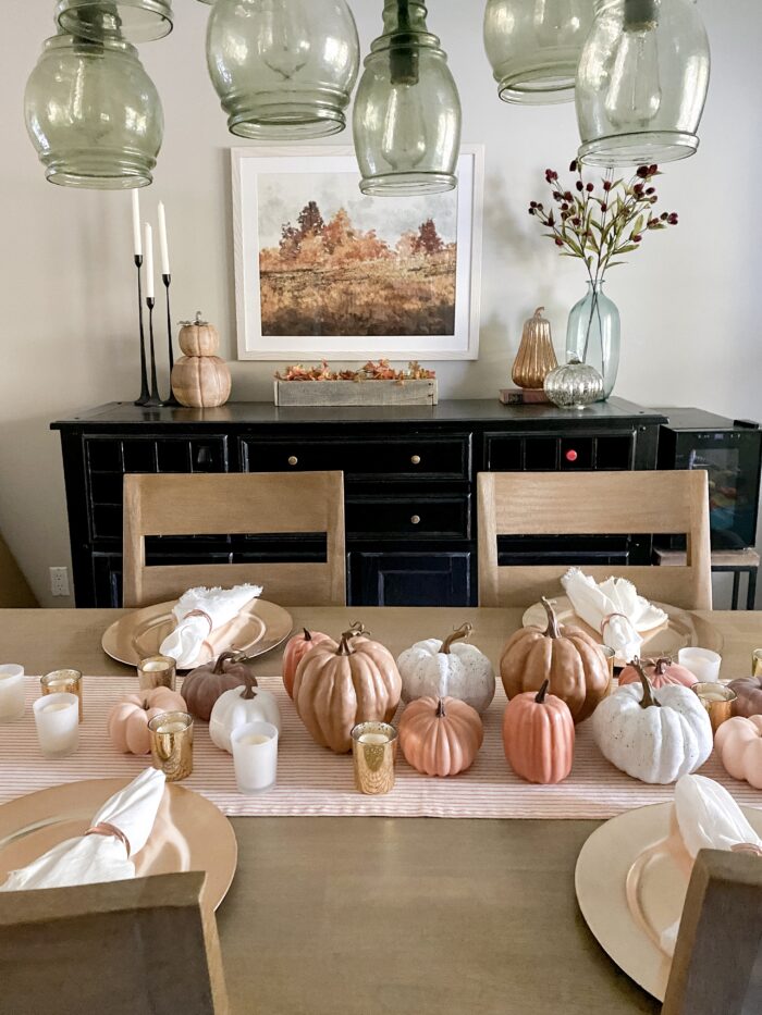 A framed picture of fall trees in a dining room