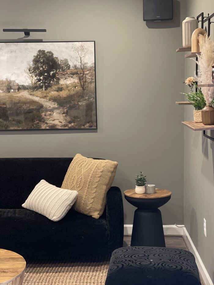 a large landscape painting hung on a living room wall