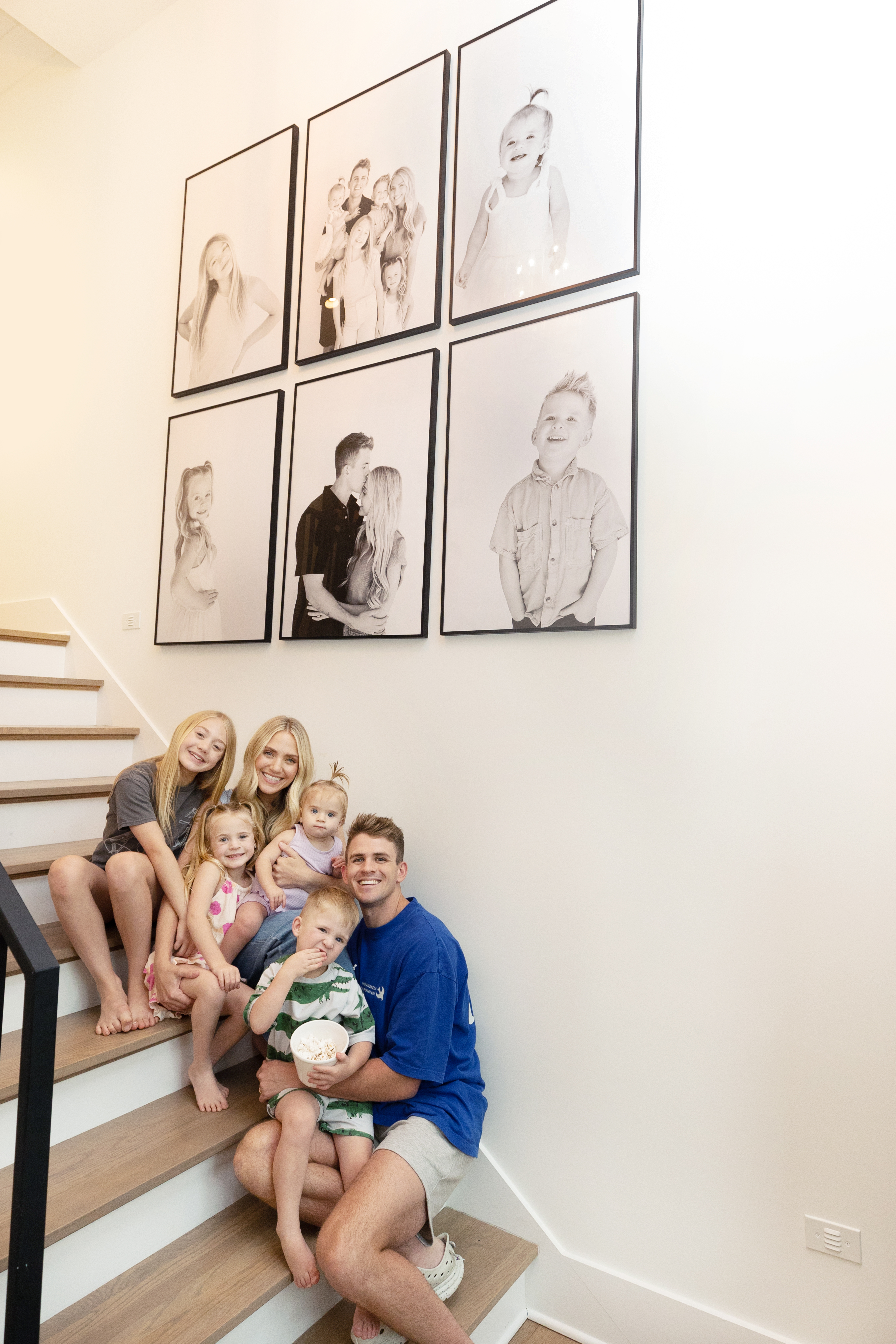 At Home Photoshoot: Family portraits framed above a staircase.