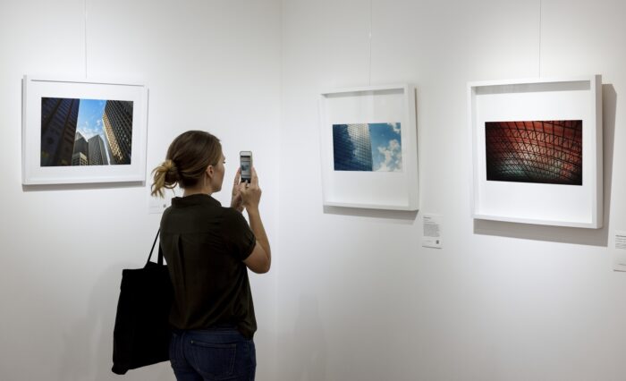 Woman in an art exhibition taking a photo of an art