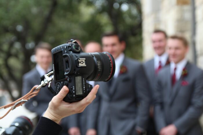 The Ultimate Wedding Photography & Display Guide: A wedding photographer captures the groomsmen. 
