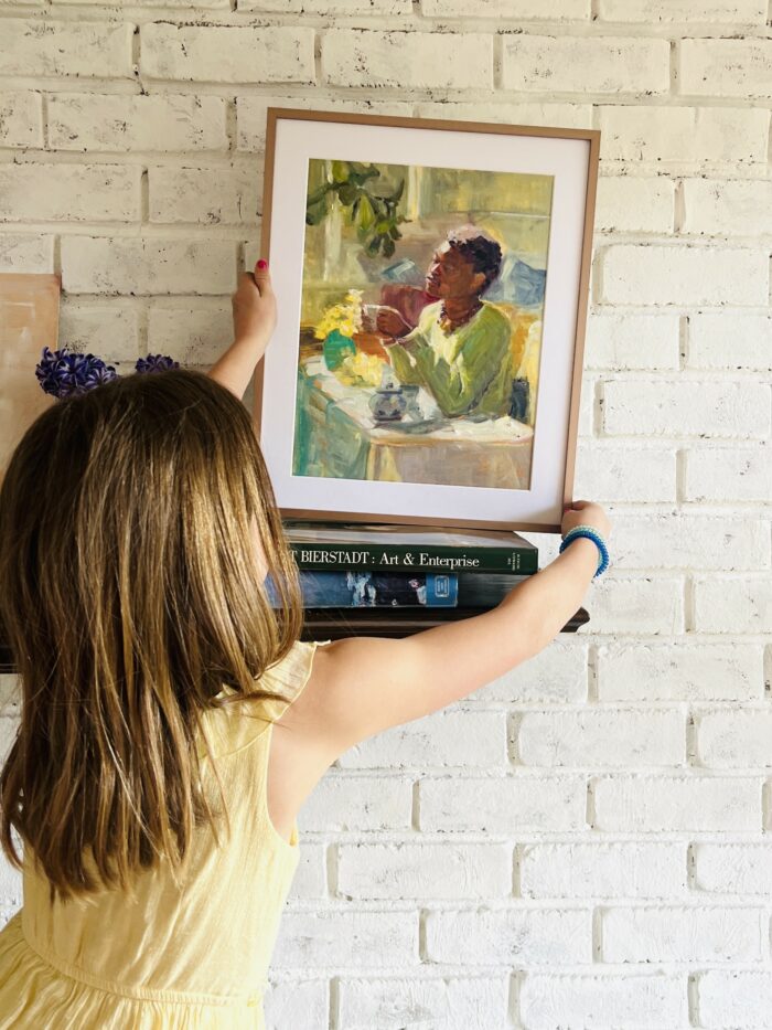 Ecommerce Tools: A girl hanging up a framed art print