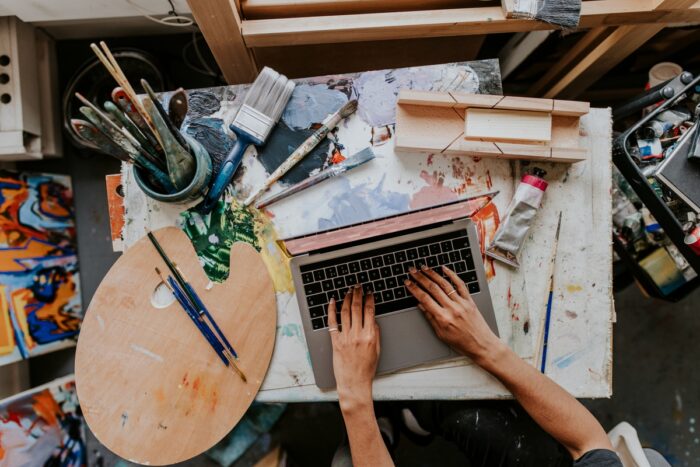 How To Build A Brand: Artist working on her laptop in her studio