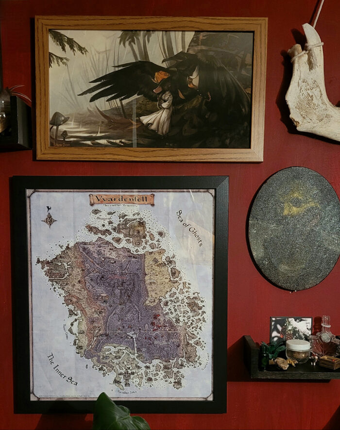Framed map and fantasy art on a game room wall