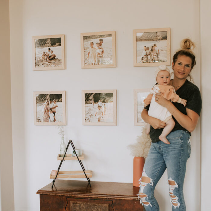 The Perfect Baby Picture Frames: a mom and baby pose by their family gallery wall