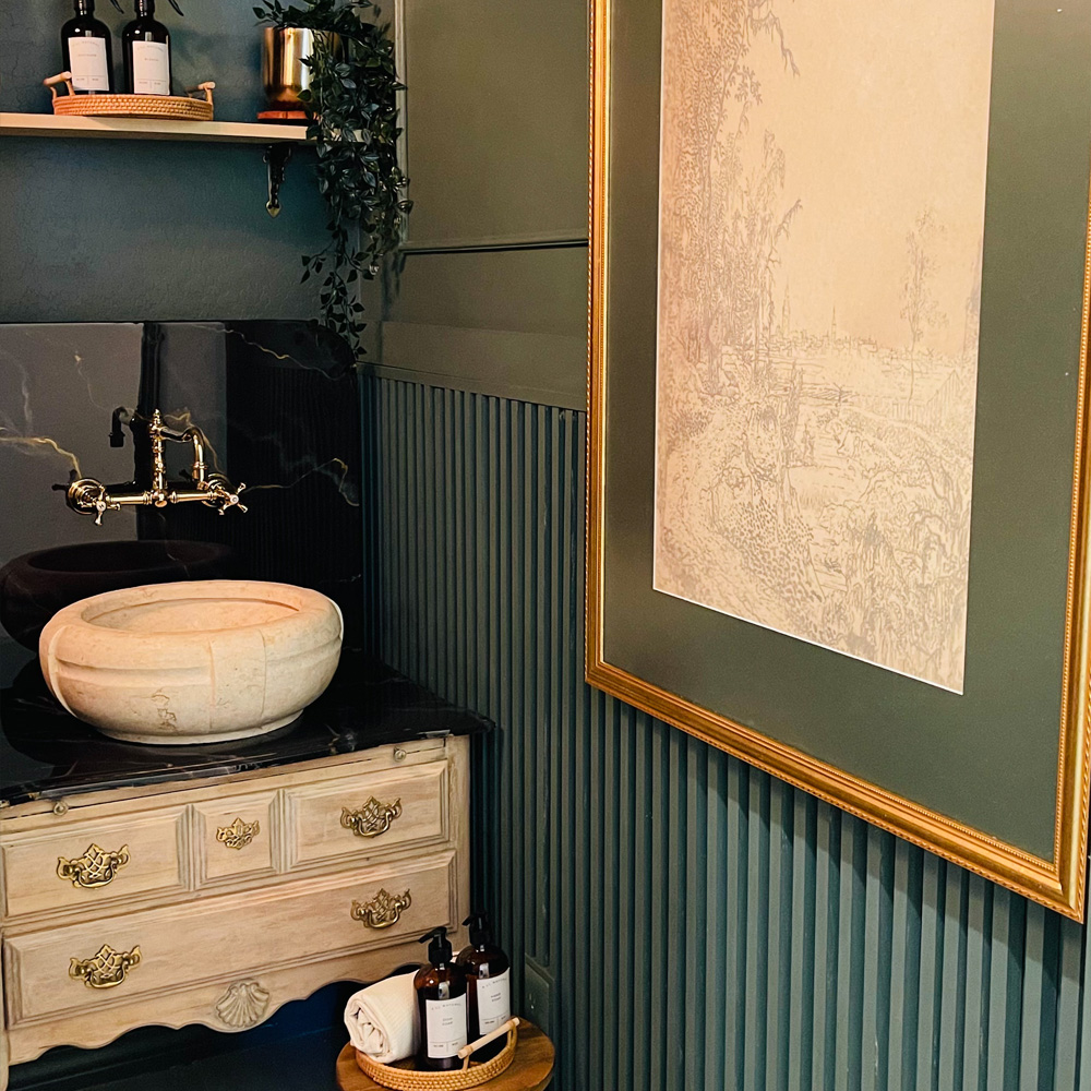 Bathroom Wall Decor Ideas: An Eccentric / Maximalist style bathroom with one large gold frame and shelf decor. 