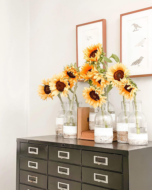 Eco-Friendly Decor Tips: framed sketches above a file cabinet of flowers.