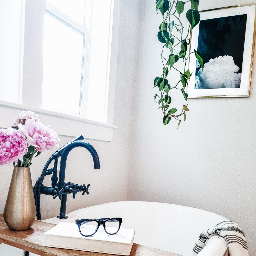 Bathroom Wall Decor Ideas: A Modern style bathroom with a floor tub, hanging plants, and a framed photo of a flower. 