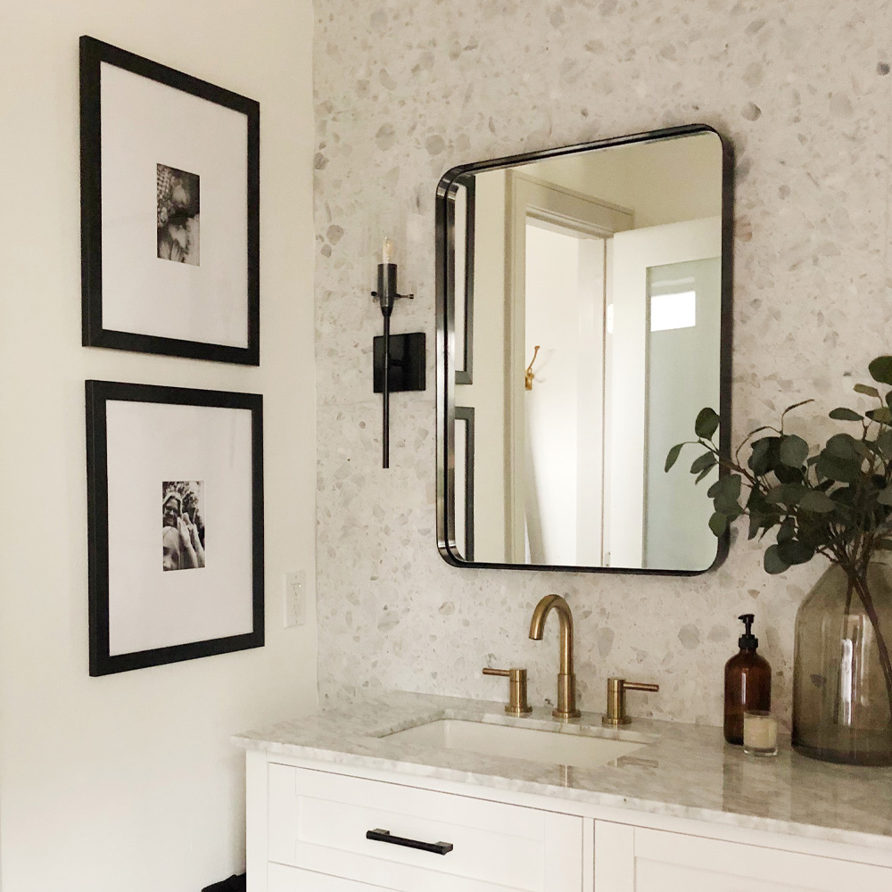 Bathroom Wall Decor Ideas: A modern style bathroom with two vertical frames and a marbled wallpaper. 