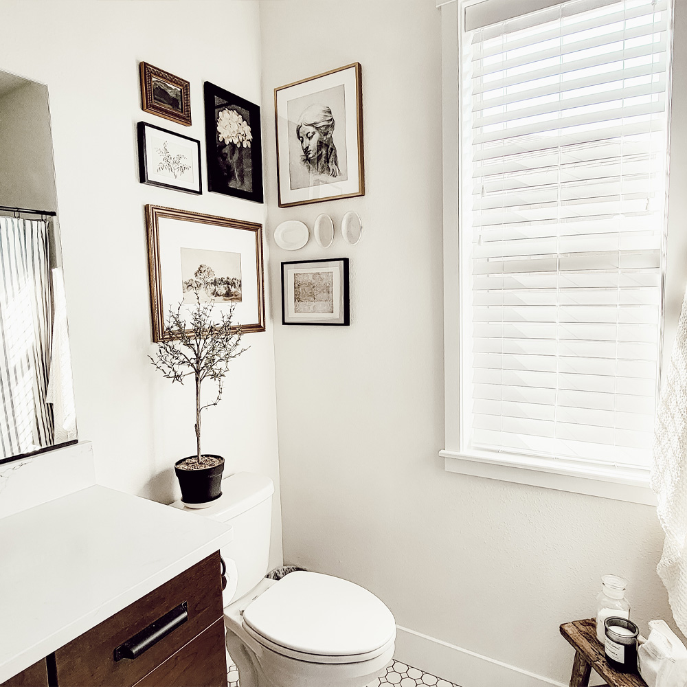 Bathroom Wall Decor Ideas: a Vintage style bathroom with framed corner art and hung plates. 