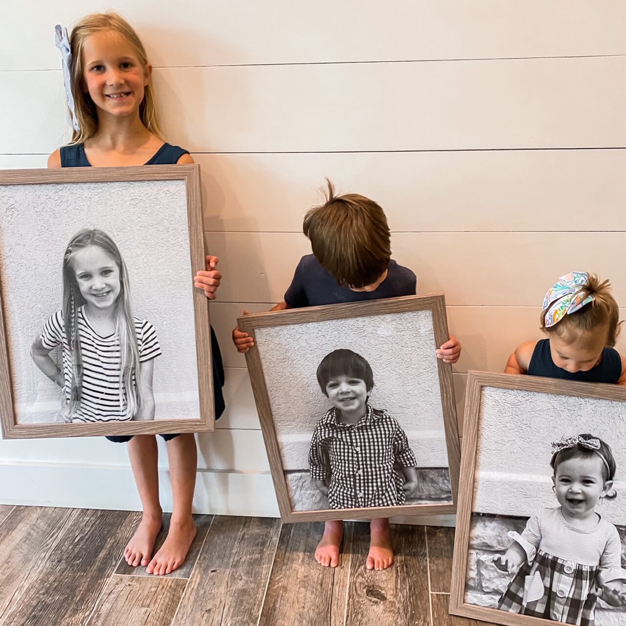 black and white family photos with natural wood picture frames
