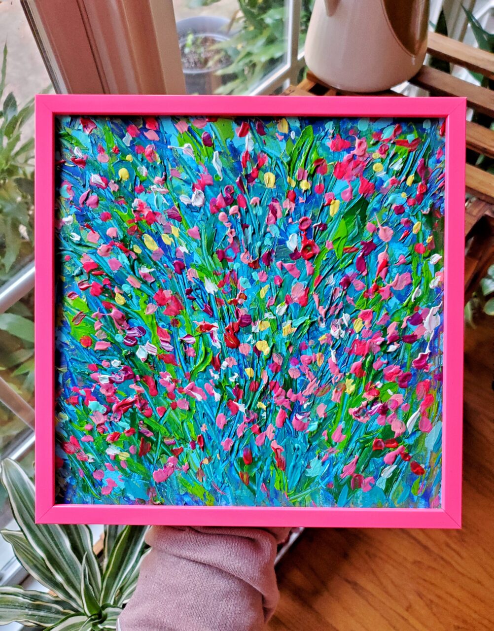Bright pink frame with colorful art. 