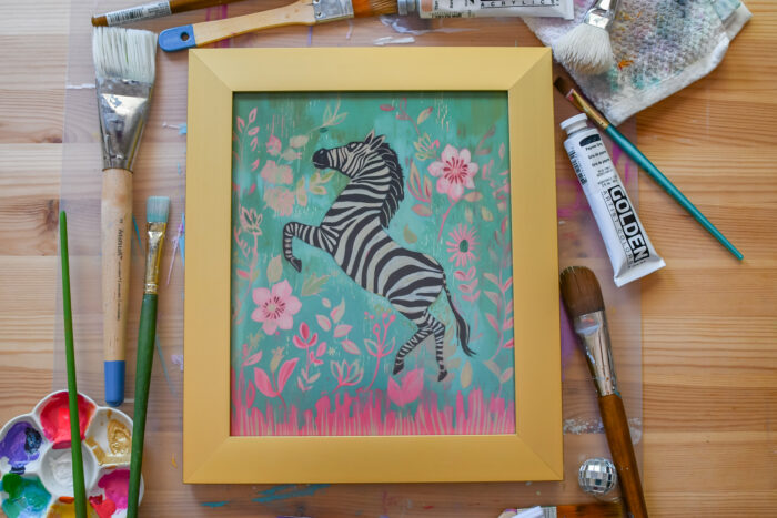 colorful art print in a gold frame
