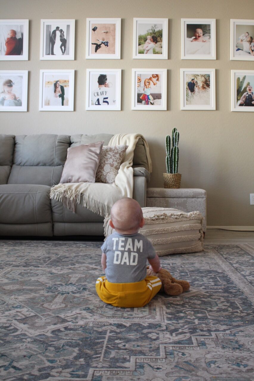 baby with Team Dad shirt with large gallery wall
