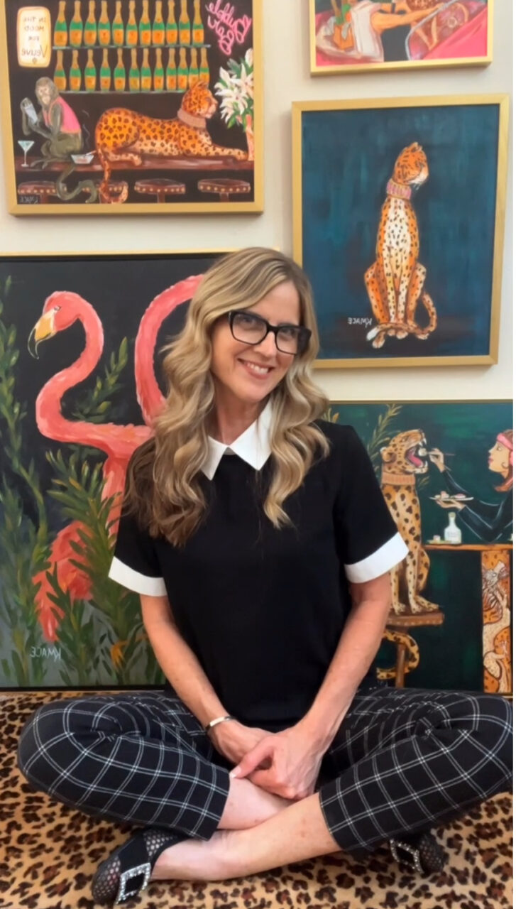 How to Price Art: A Simple Guide for Artists 1 artists in front of her framed paintings